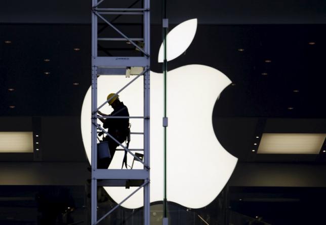 File photo of a worker climbing outside an Apple store in Hong Kong