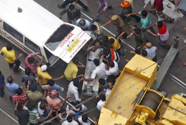Rescue members rush a policeman to an ambulance after he was rescued at the site of an under-construction flyover that collapsed in Kolkata - THEWILL NEWS MEDIA Rescue members rush a policeman to an ambulance after he was rescued at the site of an under-construction flyover that collapsed in Kolkata, India, March 31, 2016. REUTERS/Rupak De Chowdhuri