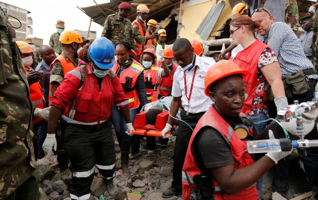 Kenya Red Cross rescuers evacuate a woman from the rubble of a six-storey building that collapsed last Friday after days of heavy rain, in Nairobi, Kenya