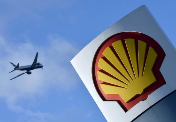 File photo of passenger plane flies over a Shell logo at a petrol station in west London
