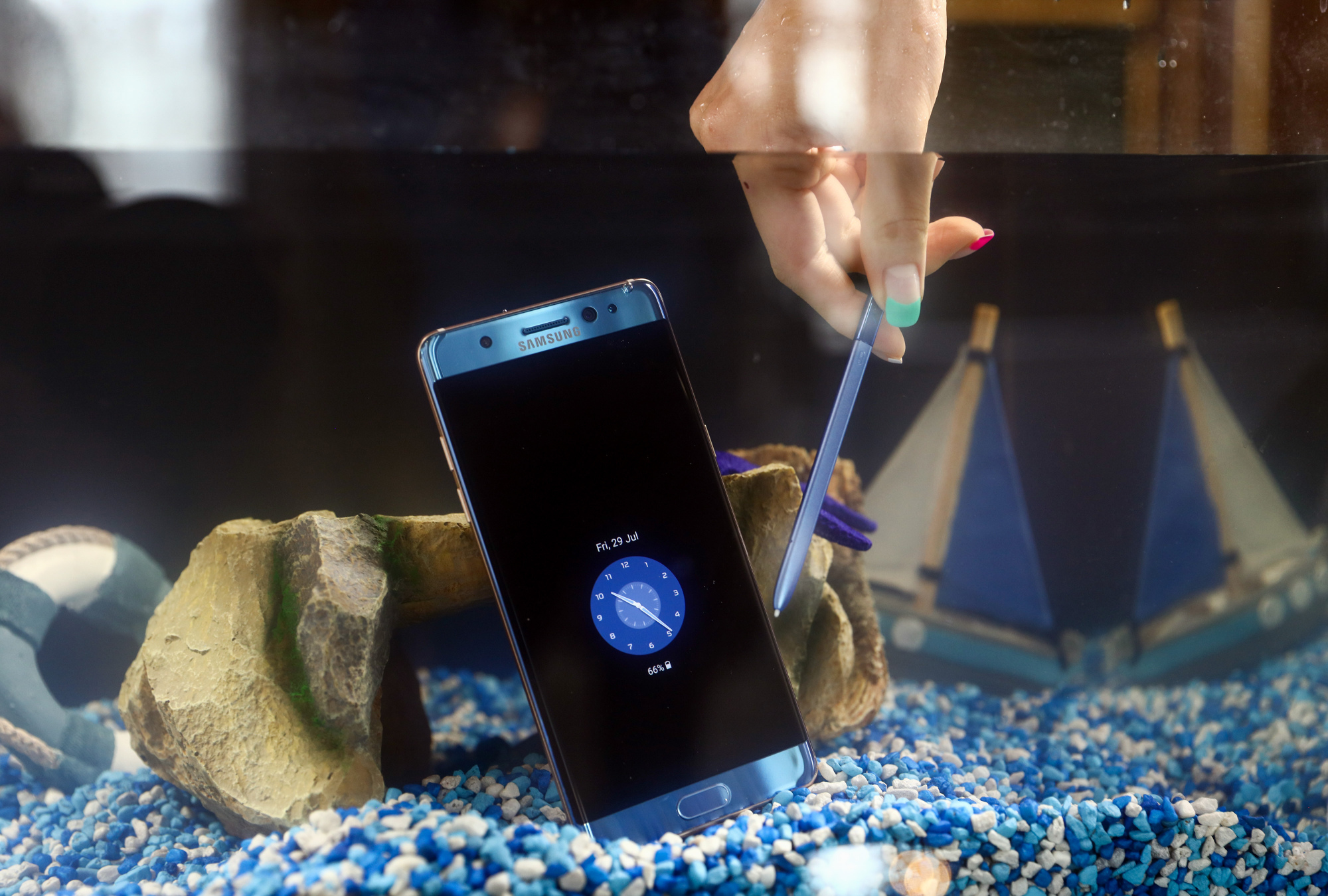 UK SAMSUNG - THEWILL NEWS MEDIA An employee holds a stylus next to a Samsung Electronics Co. Galaxy Note 7 smartphone in a tank of water during a demonstration in London, U.K., on Friday, July 29, 2016.