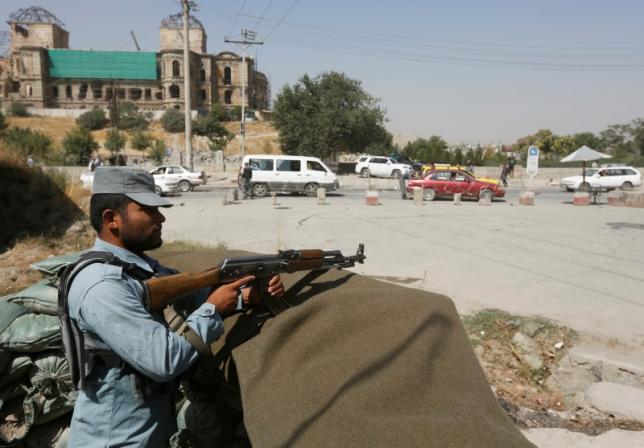 An Afghan policeman keeps watch at a checkpoint near the site of kidnapping in Kabul