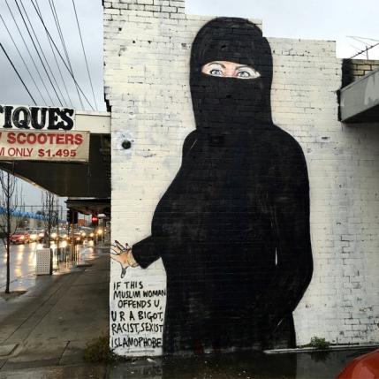 A mural painted by street artist Lushsux, bearing the image of U.S. Democratic Party nominee for President Hillary Clinton wearing islamic dress to cover over a stars-and-stripes themed swimsuit, is pictured on the wall of a business in Melbourne - THEWILL NEWS MEDIA A mural painted by street artist Lushsux, bearing the image of U.S. Democratic Party nominee for President Hillary Clinton wearing islamic dress to cover over the original artwork of a stars-and-stripes themed swimsuit stuffed with cash, is pictured on the wall of a business in the Melbourne suburb of Footscray in Australia, August 1, 2016 in this handout image provided by the artist Lushux REUTERS/Lushsux/Handout via REUTERS ATTENTION EDITORS - THIS IMAGE WAS PROVIDED BY A THIRD PARTY. EDITORIAL USE ONLY NO RESALES. NO ARCHIVE. TPX IMAGES OF THE DAY