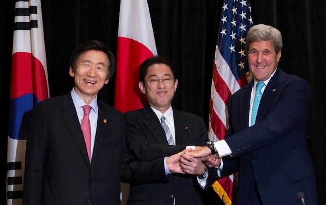 Minister of Foreign Affairs Yun Byung-se of South Korea, Minister of Foreign Affairs Fumio Kishida of Japan, and U.S. Secretary of State John Kerry join hands during a meeting between the three leaders in New York