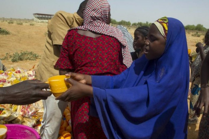 A Nigerian woman who returned from Niger receives a cup of tea at a registration centre at Geidam stadium