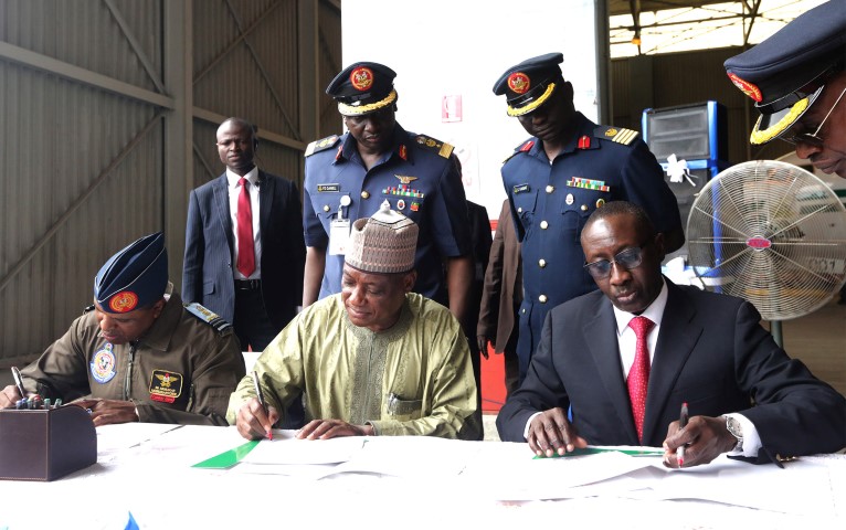 two-presidential-helicopter-4 - THEWILL NEWS MEDIA FGN DONATES TWO PRESIDENTIAL HELICOPTERS 4. L-R; Signing the handover doc; Chief of Air Staff, Air Marshall Sadique Abubakar, Minister of Defence, Brig General Mansur Dan-Ali and NSA, Major General Babagana Mongonu as two Presidential Helicopters been handed over to the Nigerian Airforce at the Presidential wing of Nnamdi Azikwe International Airport in Abuja. PHOTO; SUNDAY AGHAEZE. OCT 10 2016.