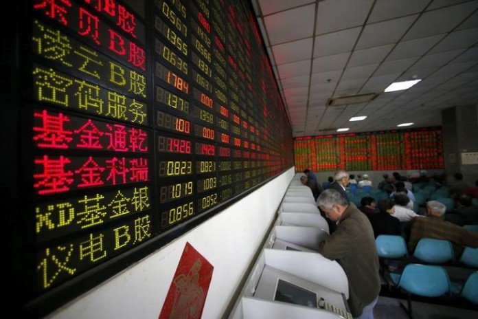 Investors look at computer screens showing stock information at a brokerage house in Shanghai