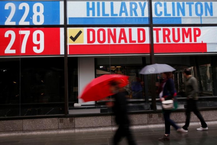 People walk by an electronic billboard in New York