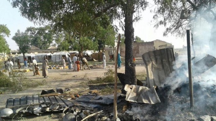 People walk at the site after a bombing attack of an internally displaced persons camp in Rann People walk at the site after a bombing attack of an internally displaced persons camp in Rann, Nigeria January 17, 2017. MSF/Handout via Reuters