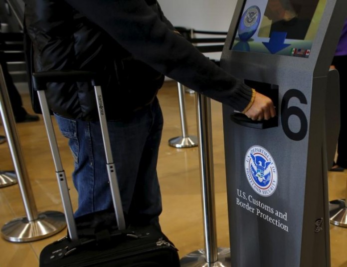 A traveler has his passport scanned as he passes through U.S. Customs and Immigration after using the Cross Border Xpress pedestrian bridge between San Diego and the Tijuana airport