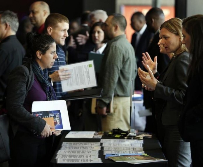 Legal firm Hogan Lovells representative Nina LeClair talks to U.S. military veteran applicants at a hiring fair for veteran job seekers and military spouses at the Verizon Center in Washington