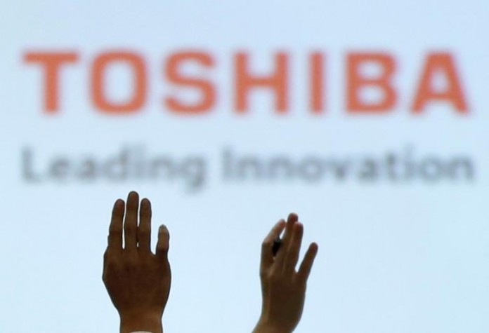 Reporters raise their hands for a question during a news conference by Toshiba Corp CEO Satoshi Tsunakawa and other senior sompany officials at the company's headquarters in Tokyo, Japan