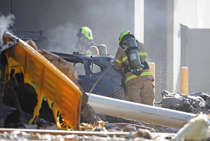 Emergency services personnel are seen at the scene of a plane crash in Essendon in Melbourne