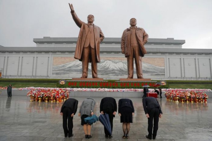 People pay their respects at the statues of North Korea founder Kim Il Sung and late leader Kim Jong Il in Pyongyang