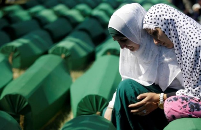 FILE PHOTO: Muslim women cry near coffins of their relatives, who are newly identified victims of the 1995 Srebrenica massacre, which are lined up for a joint burial in Potocari near Srebrenica
