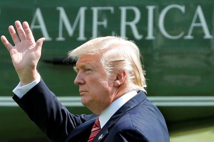 U.S. President Donald Trump waves as he walks on South Lawn of the White House in Washington
