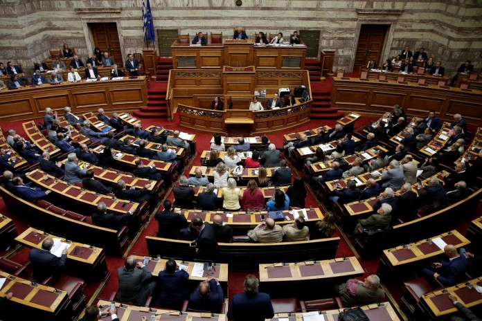 Greek Prime Minister Alexis Tsipras addresses lawmakers before a parliamentary vote of a law that allows citizens to declare a gender change on official documents in Athens