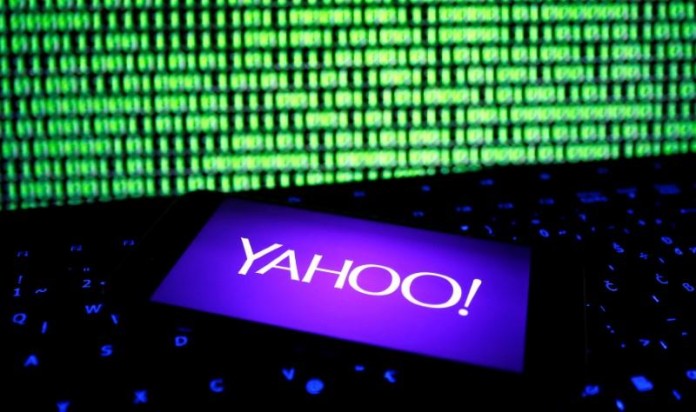A photo illustration shows a Yahoo logo on smartphone in front of a displayed cyber code and keyboard
