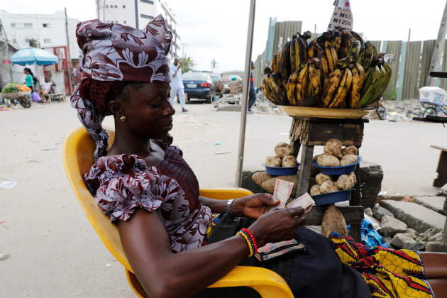 A man counts the Nigerian naira at a near currency exchange market district in Lagos.