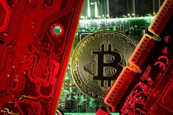 FILE PHOTO: A copy of bitcoin standing on PC motherboard is seen in this illustration picture