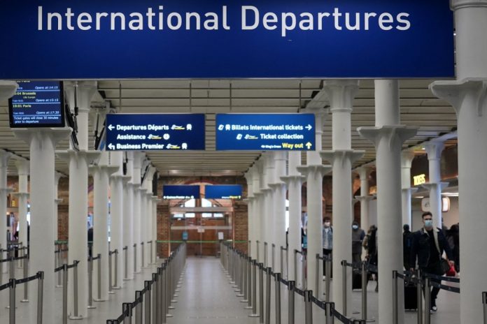 BRITAIN-HEALTH-VIRUS-TRANSPORT Travellers wearing protective face coverings to combat the spread of the coronavirus prepare to depart on the high-speed Eurostar service from St Pancras International railway station in London on December 20, 2020. - European countries banned flights coming from the UK on Sunday as the British government warned that a potent new strain of the virus was "out of control". Belgium is suspending flights and trains from the United Kingdom from midnight Sunday. (Photo by Niklas HALLE'N / AFP)