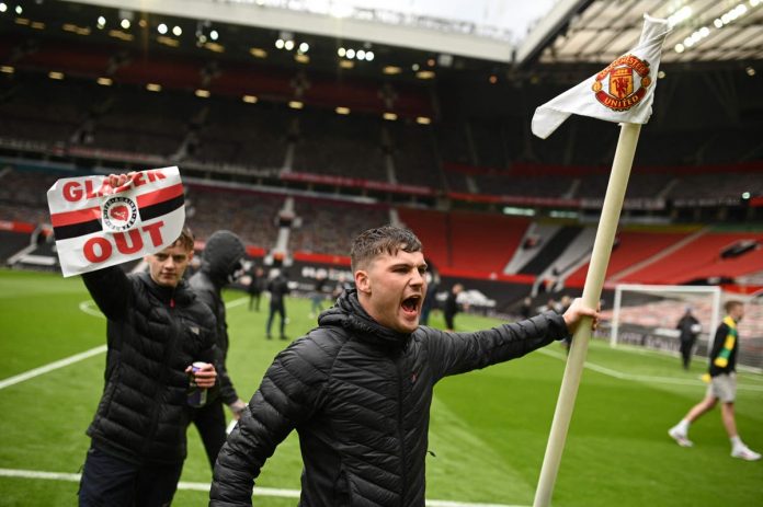 United supporters on the Old Trafford pitch