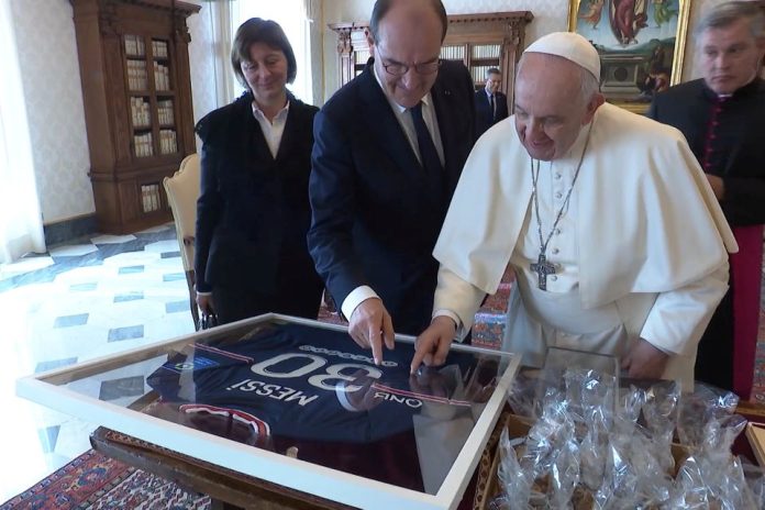 Pope Francis receives a Paris Saint Germain jersey signed by Argentine Lionel Messi as a gift from French Prime Minister Jean Castex during a private audience at the Vatican, October 18, 2021