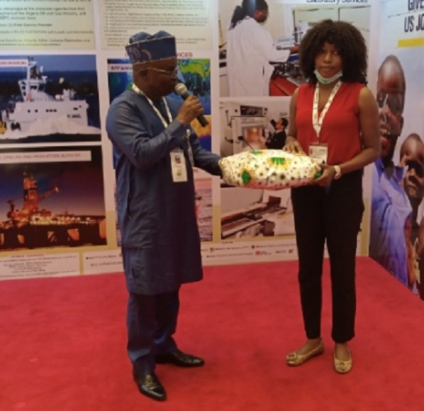Mr Johnson Awoyomi, Managing Director, NETCO, presenting a gift Miss Mercy Obasi, winner of the raffle draw competition held at NETCO'S exhibition stand at the Nigerian Association of Petroleum Explorationists (NAPE) 2021 Conference on Tuesday in Lagos. 