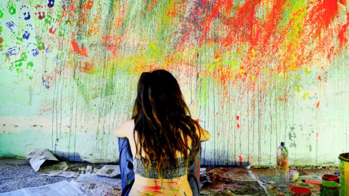 Rear View Of Woman Sitting On Floor Against Messy Wall Rear View Of Woman Sitting On Floor Against Messy Wall