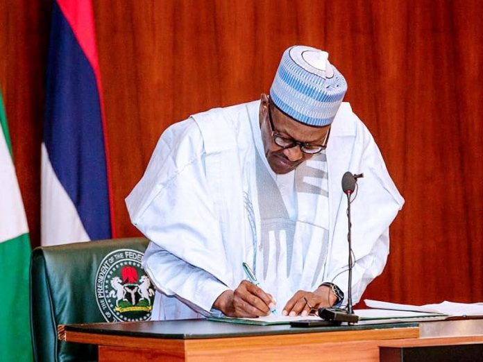 President-Buhari-signs-1 President Muhammadu Buhari