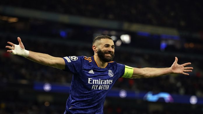 Real Madrid's Karim Benzema celebrates after scoring his side's third goal from penalty during the Champions League semi final, first leg soccer match between Manchester City and Real Madrid at the Etihad stadium in Manchester, England, Tuesday, April 26, 2022. (AP Photo/Dave Thompson)