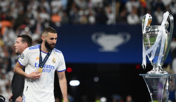 Real Madrid's French forward Karim Benzema walks past hte trophy after winning the UEFA Champions League final football match between Liverpool and Real Madrid at the Stade de France in Saint-Denis, north of Paris, on May 28, 2022. (Photo by FRANCK FIFE / AFP)