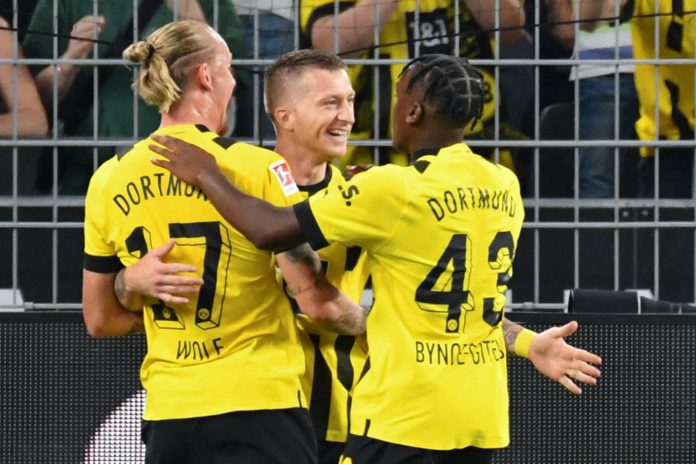 FBL-GER-BUNDESLIGA-DORTMUND-HOFFENHEIM Dortmund's German forward Marco Reus (C) celebrates after scoring a goal with DortmundÂ’s German midfielder Marius Wolf (L) and Dortmund's English forward Jamie Bynoe-Gittens during the German first division Bundesliga football match between BVB 09 Borussia Dortmund and TSG 1899 Hoffenheim in Dortmund, western Germany on September 2, 2022. (Photo by UWE KRAFT / AFP) / DFL REGULATIONS PROHIBIT ANY USE OF PHOTOGRAPHS AS IMAGE SEQUENCES AND/OR QUASI-VIDEO