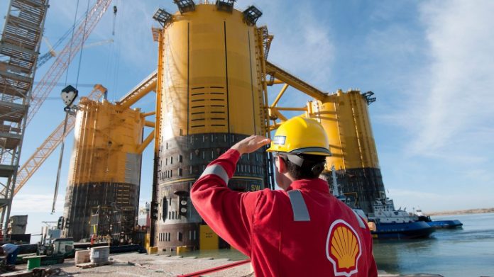 Shell engineer-in-red-uniform-with-yellow-hard-hat-by-marsb-platform-construction Shell - engineer-in-red-uniform-with-yellow-hard-hat-by-marsb-platform-construction