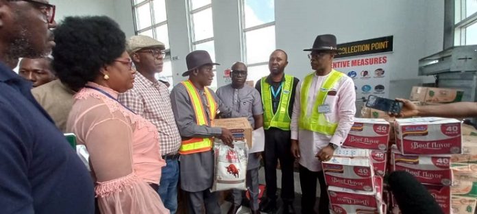 Chimara Imediegwu, Director, Flight Operations, United Nigeria Airlines (middle) presenting the relief materials to representatives of the host Communities In Yenagoa recently