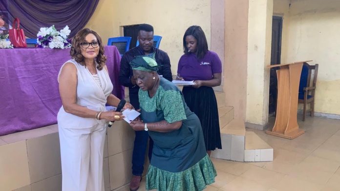 The founder of Jedidiah Divine Home Of Love (JEDLOF), Dr. (Mrs) Ebele Okoye, presenting a cheque to one of the beneficiaries at the event.
