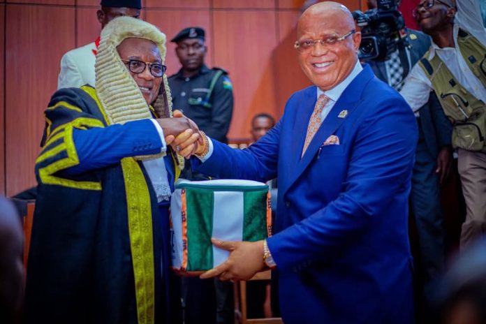 pic of Akwa Ibom State Governor, Pastor Umo Eno Ph.D, presenting the budget document to the Speaker of the State House of Assembly, Rt. Hon. Udeme Otong on Tuesday.