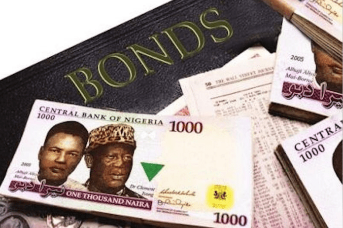 0c815c07-fgn-bonds Close-up of Nigerian 1000-naira banknotes fanned out on a surface with the word 'BONDS' in gold lettering above them.