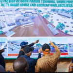 Maritime Experts Push For Blue Economy Ministry As 6,208 Firms Operate Along Akwa Ibom Coast Group of men gathered around a large banner, pointing at a proposed marine terminal and facilities layout with labeled diagrams.