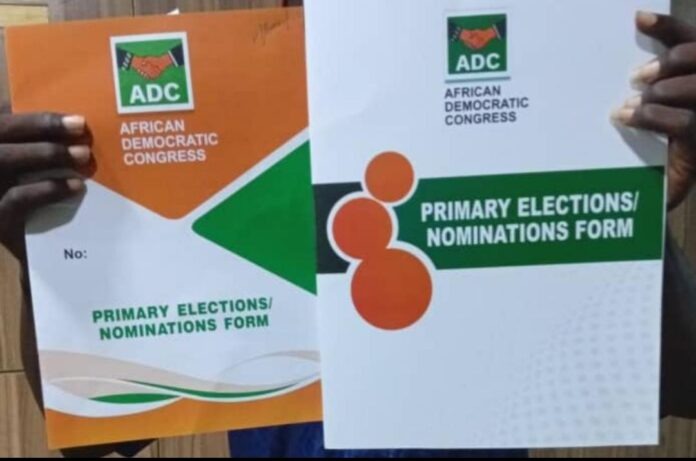 Ogun 2027: US-Based Physician Dr Odusina Formalises Guber Bid On ADC Platform Two hands hold up ADC political party nomination forms, one orange and one white/green, with the African Democratic Congress logo and 'Primary Elections/Nominations Form' text visible.