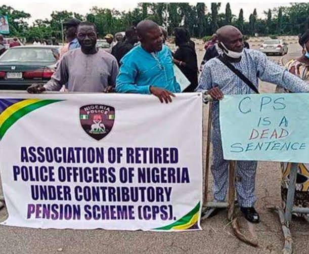 Retired police Officers Group of men protesting, holding a banner that reads 'Association of Retired Police Officers of Nigeria Under Contributory Pension Scheme (CPPS)' with a sign saying 'CPS is a dead sentence'
