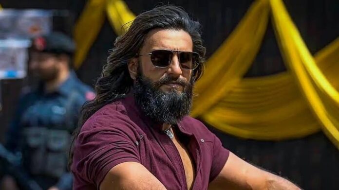 IMG_5917 Bearded man with long hair and sunglasses wearing a maroon shirt, posing outdoors.