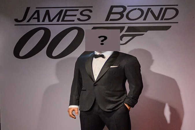Life-size James Bond display in a black tuxedo, with a gray panel bearing a question mark over the head.