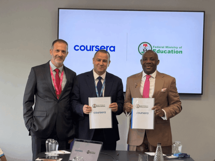 Three men in suits pose for a photo at an education signing event with Coursera and Federal Ministry of Education logos on the screen behind them with documents in hand.