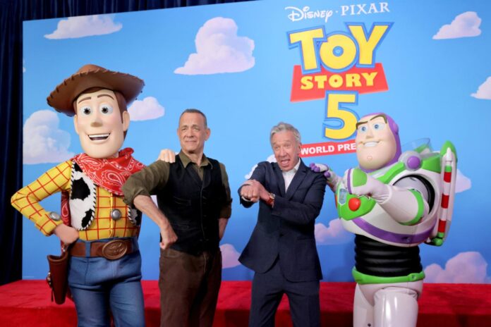Two men posing with life-size Woody and Buzz Lightyear figures on a Toy Story 5 backdrop.