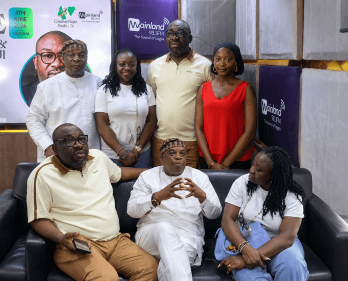 1002657730 Seven people pose together in a Mainland Radio studio, with 98.3FM banners in the background.
