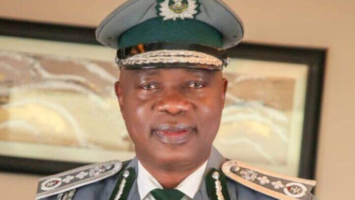 Portrait of a senior police officer in full dress uniform, green peaked cap, and decorative shoulder insignia, facing the camera.