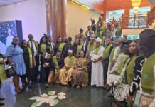 Jurists Harp On Growing Importance Of ADR In Advancement Of Justice Group of people in green sashes posing for a formal group photo in a lobby with stairs and a chandelier behind them. They are dressed in varied formal attire, some holding books or programs, with two individuals seated in front.