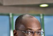 Tinubu Appoints Kunle Elebute Chairman Of Financial Reporting Council Board Professional portrait of a Black man in a navy suit and glasses, looking at the camera with a neutral expression.