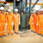 OPINION:Why Akwa Ibom’s ₦7.38bn Bet On Women Could Redefine Grassroots Development BY Ekaette Okon-Joseph Group of workers in orange coveralls and white hard hats standing around a large drilling machine outdoors.